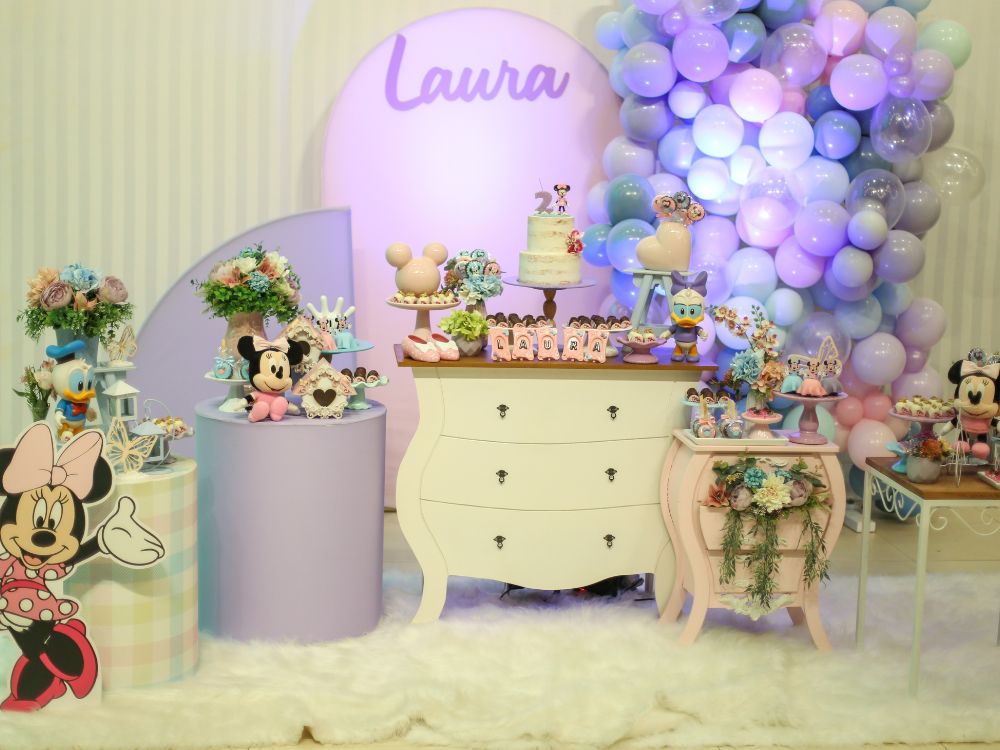 Decoração de festa infantil em tons pastel com personagens da Disney, mesa de doces personalizada, balões lilás e detalhes delicados para aniversário infantil feminino.